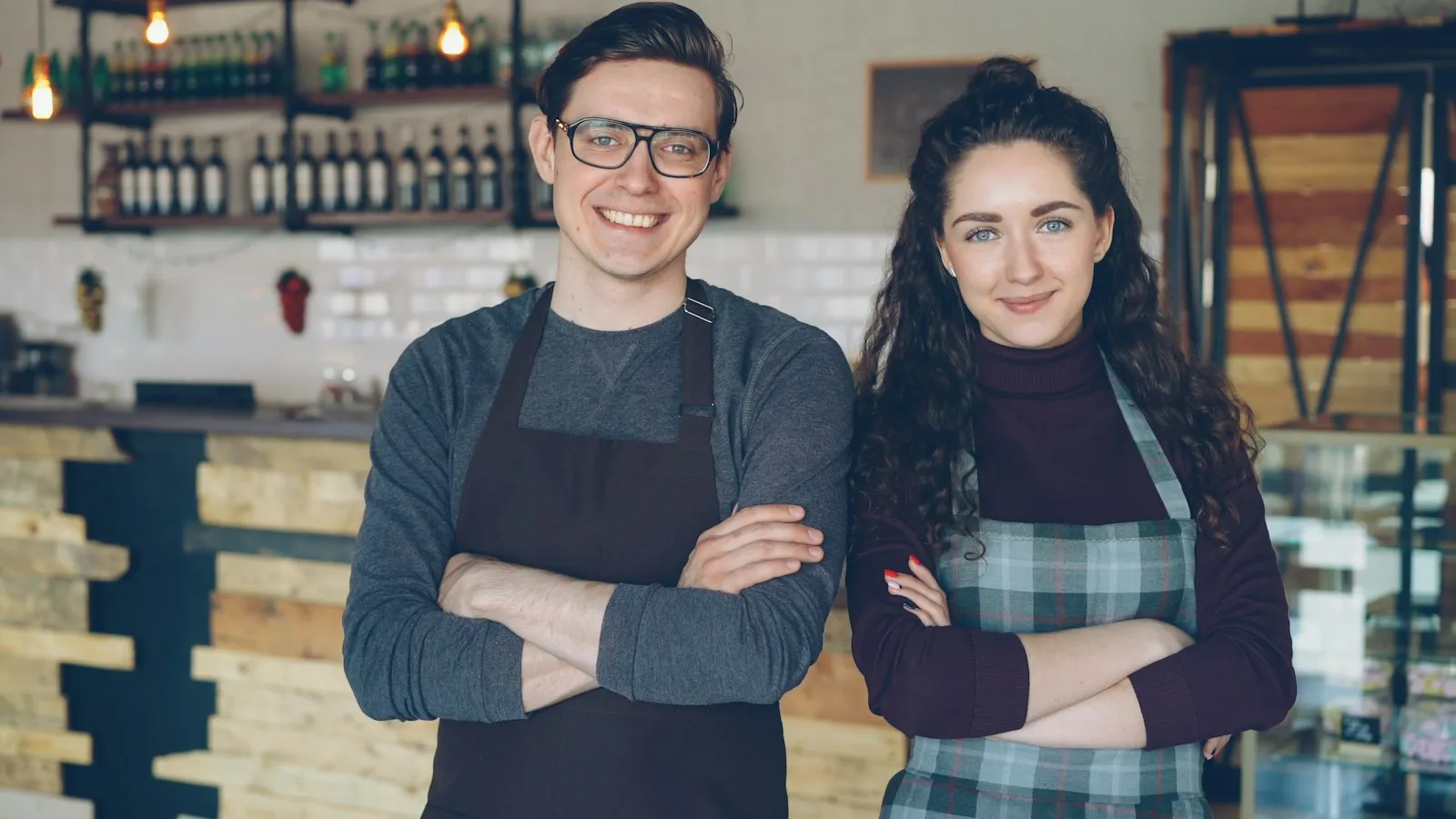 Dois donos de um café à porta do seu negócio